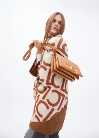 Faux leather crossbody bag with three compartments and flap.